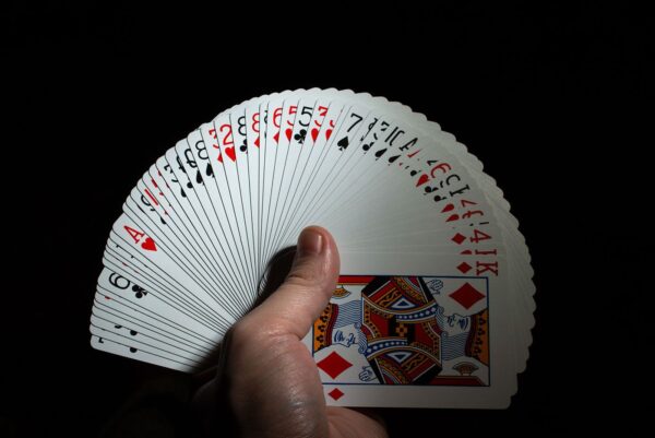 hand hold a fan from a deck of poker cards on a black background copy space. close up